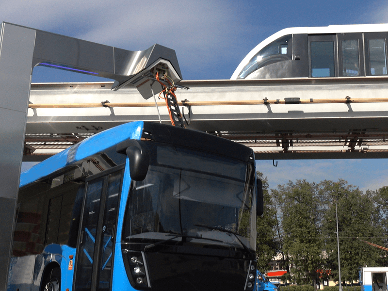 Electric bus on roadway and light rail trail on an overpass