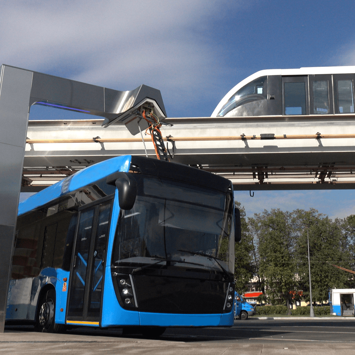 Electric bus on roadway and light rail trail on an overpass